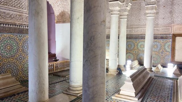 Interior view of the ornate Saadian tombs in Marrakech. Ancient mausoleum complex features decorative mosaic tilework and marble columns. This historic royal necropolis is a famous landmark/