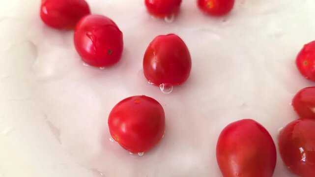 Fresh cherry tomatoes roll in water