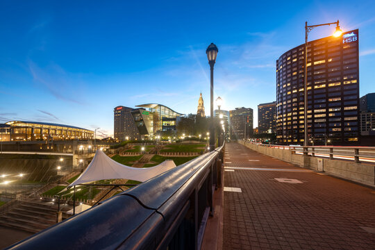 A pedestrian walkway on the Founders Bridge leads toward the urban architecture and riverside district of Hartford, Connecticut.