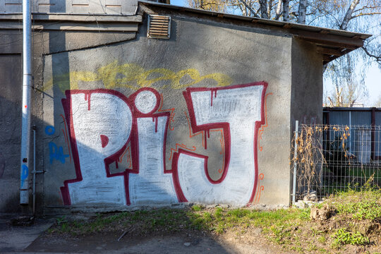 Warsaw, Masovian Voivodeship, Poland - April 04 2026: A vibrant white and red graffiti piece spelling "PIJ" on a weathered concrete wall outdoors.