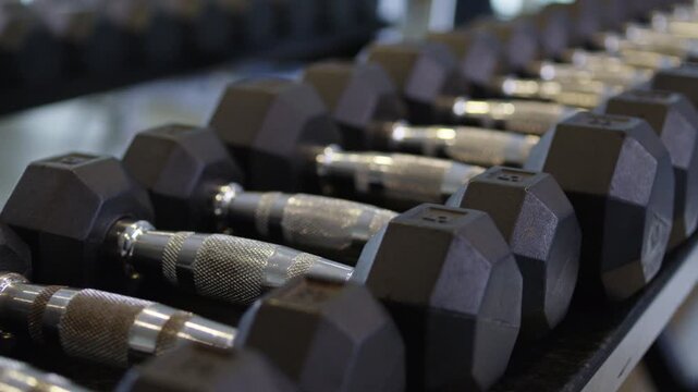 Aesthetic close-up shot of a bunch of dumbbells at a modern gym.