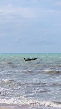 Traditional Brazilian Jangada Fishing Raft with Fisherman on Turquoise Ocean. Artisanal Fishing, Ceara, Northeast Brazil