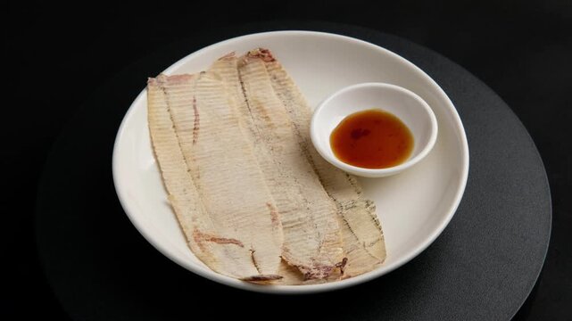 Crushed Dried Squid,Thai Seafood Snack in a plate.served with sauce.