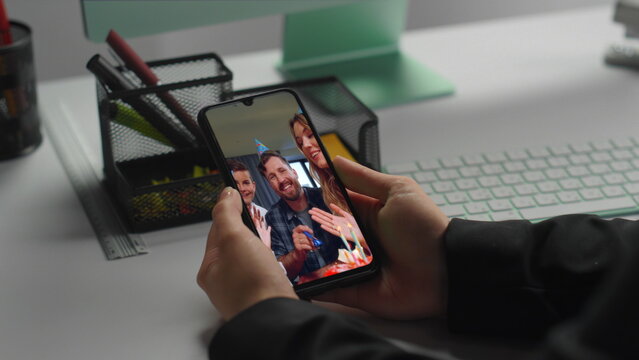 Woman looking smartphone screen at work place closeup. Lady watching video call
