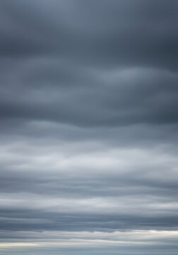 A massive, dense layer of uniform gray clouds covering the entire upper atmosphere, creating a moody, subdued, and overcast natural backdrop, overcast, background, day