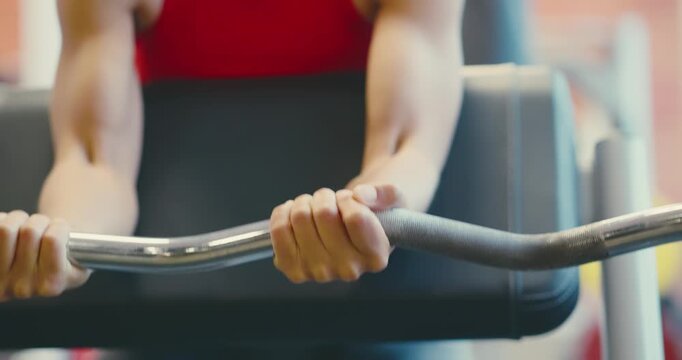 Person Performing Preacher Curl Exercise in Gym