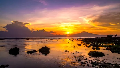 Poster Reflectie Rocky beach during sunset, sky ablaze with orange and purple hues reflected on the water's surface, silhouetted mountain  © gori
