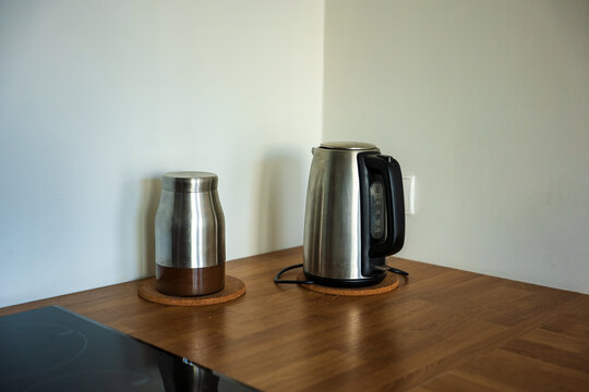 Stainless steel kettle and canister on cork trivets in kitchen corner