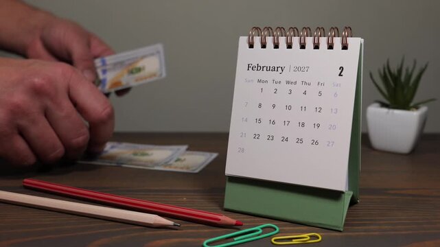February 2027 Calendar With Credit Card Payment Planning on Desk