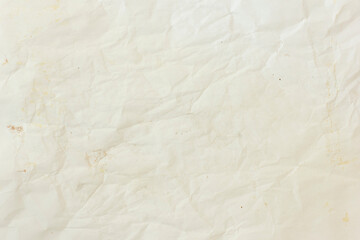 Fototapeta premium Off white slightly crumpled paper texture. Blank beige creased sheet surface with light stains for vintage retro design