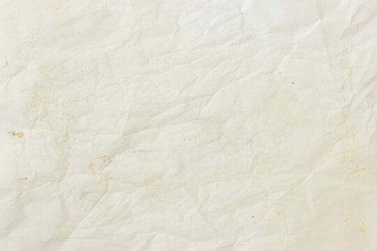 Off white slightly crumpled paper texture. Blank beige creased sheet surface with light stains for vintage retro design