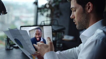 Fototapeta premium Boss conducting online meeting checking documentation on desk office closeup. 