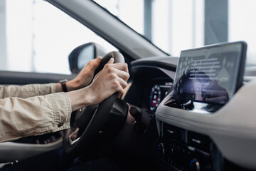 Fototapeta premium Person controlling car with hands on wheel in modern vehicle. Driving concept. 