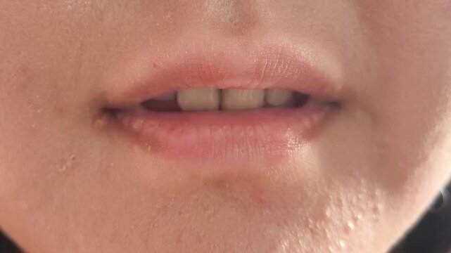 Close-up of a woman begins to smile. Smile of a girl with beautiful natural straight teeth. Dentistry