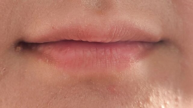 Close-up of a woman begins to smile. Smile of a girl with beautiful natural straight teeth. Dentistry