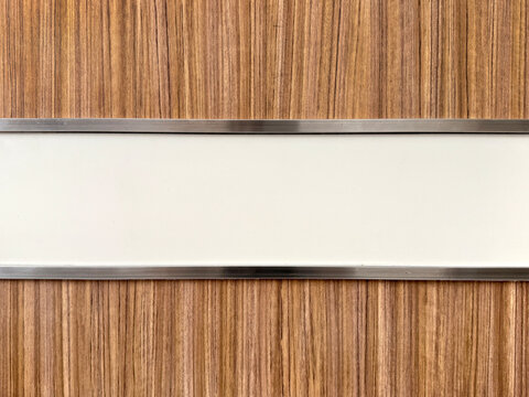 Close up of natural wood panel with white horizontal stretch and mirror stainless steel trimming. Seamless background texture.
