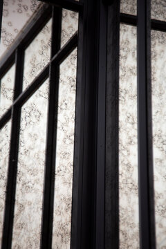 Vintage mirror with black metal frame and patterned wall reflection