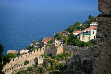 Naklejka premium Ancient stone walls of Alanya Castle overlooking Mediterranean Sea, Turkey. Medieval fortress architecture, coastal city heritage, scenic travel destination, historical fortification concept