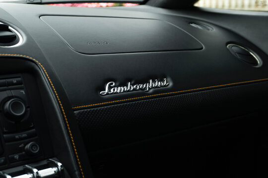 Lamborghini Gallardo passenger dashboard with chrome logo, Luxury supercar interior badge on leather