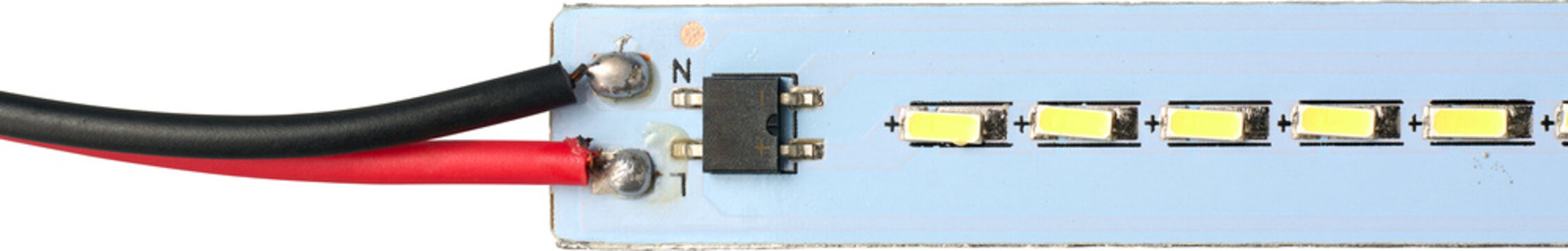closeup of blue led strip circuit board with soldered red and black wires isolated white background, yellow led components and black electronic chip