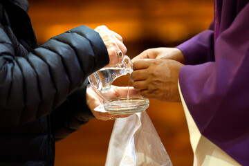 Saint Maurice church.  Purification rite as water is carefully poured over the celebrant's hands before consecration.  Thones. France.