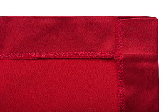 Detailed view of red cloth corner with overlock stitching, finished fabric edge, sewing and tailoring concept, isolated