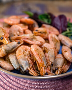 Fresh boiled shrimp with herbs on a plate. Full plate of juicy shrimp closeup