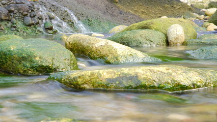 Background of river rocks covered with green moss © baihaqi