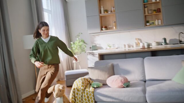 Active daughter catching mother running sunshine living room. Girl mom playing