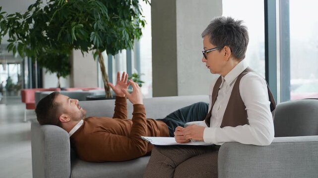 Male patient talking during psychotherapy session with therapist