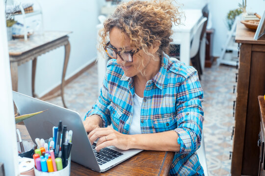 Woman working on laptop at home desk, remote work and freelance productivity in casual setting
