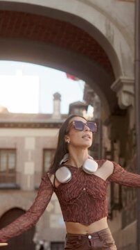 Happy energetic young woman dancing in a european city street