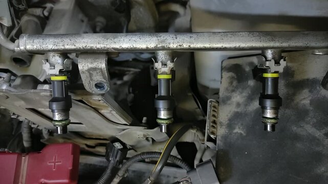  Fuel rail with injectors and yellow rings on car engine