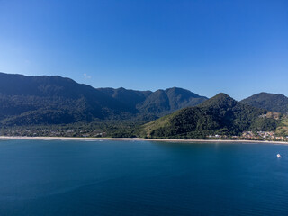 Fototapeta premium Aerial wide view of Guaeca beach and Rio-Santos highway winding through lush green mountains in Brazil
