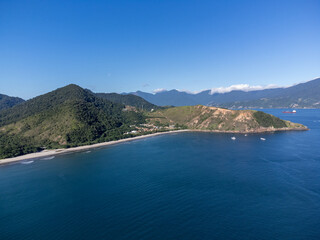Obraz premium Aerial wide view of Guaeca beach and Rio-Santos highway winding through lush green mountains in Brazil