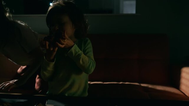 Two boys eating pizza on the sofa while watching a movie