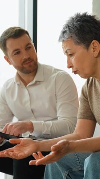 Psychologist comforting desperate senior woman during therapy session