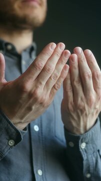 Muslim man praying with his hands together in close up shot, deeply engaged in spiritual moment of worship, devotion while connecting with his faith, seeking solace from god. Man praying with hands