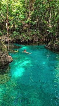 Woman swimming in lake with crystal blue water in Sulawesi, Indonesia
