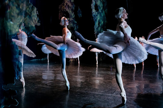 Classical ballerinas performing elegant ballet dance on stage.
