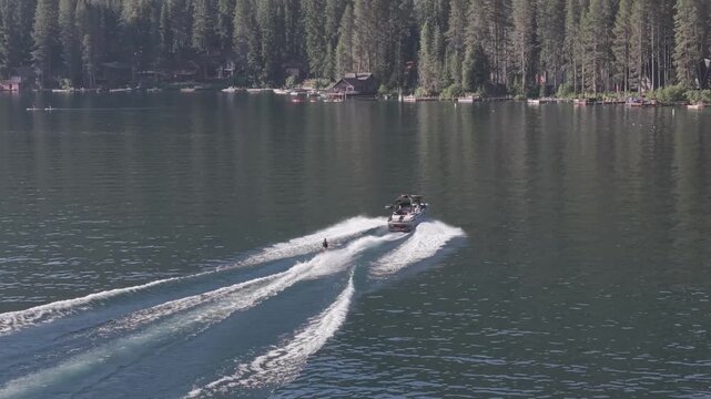 Aerial Drone View Following Motorboat Across Mountain Lake in California waterskier