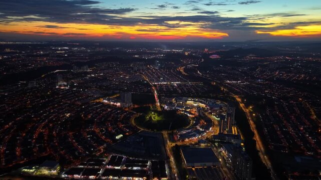 Top down drone shot capturing the geometric light patterns of the bustling Bukit Indah intersection.