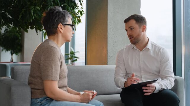 Psychologist having a therapy session with a sad mature woman
