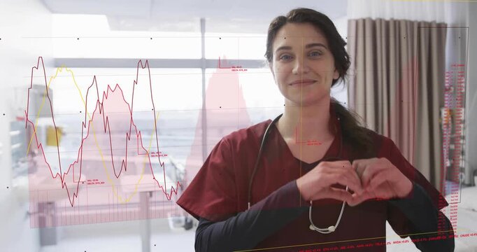 Nurse forming heart gesture in ward as animated line charts appearing and showing patient care