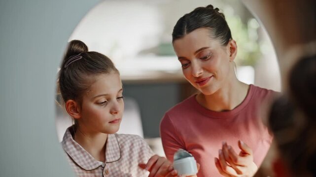 Mother daughter beauty routine closeup. Teenager aunt pampering faces at mirror