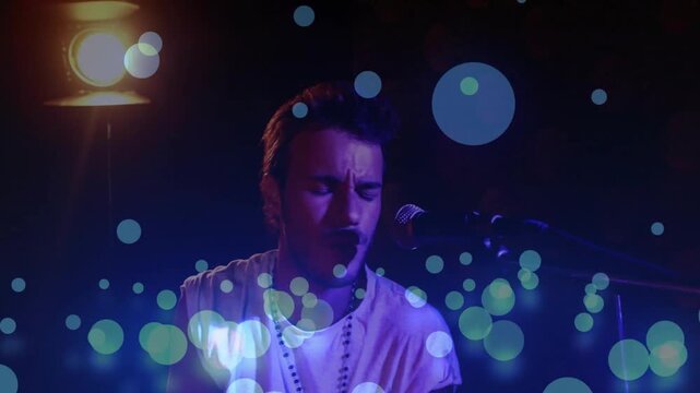 Musician starting tapping sticks rising to hard hit, leaning to mic, singing, bokeh amplifying mood