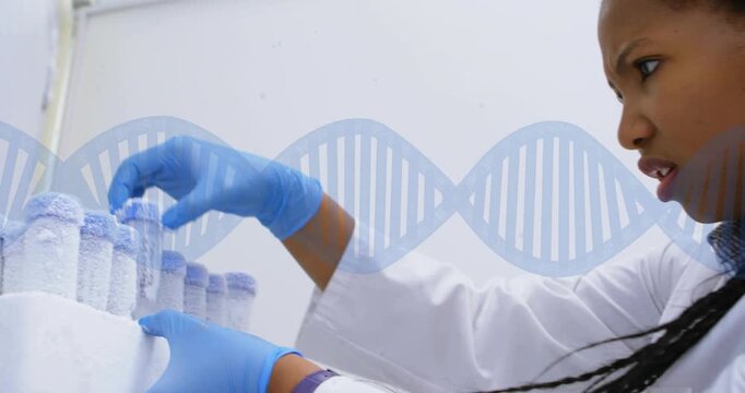 After rack removal from freezer tech lifting frozen vial inspecting under DNA helix for testing