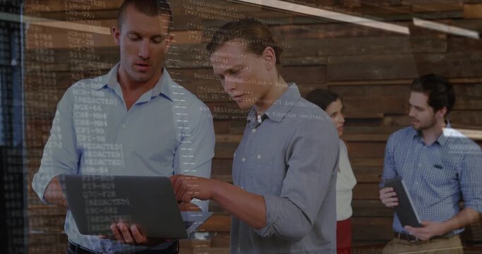 Two men holding laptop and pointing screen, creating code overlay while dev team reviewing plans