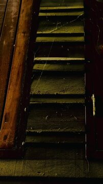 A close-up image of the wall of an old wooden house, more than a century old, reveals the texture, cracks, and dust and cobwebs that have been left untouched by time, reflecting the historical archi