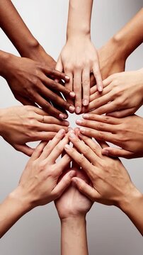 A diverse group of people placing their hands together in a circle to show unity and support